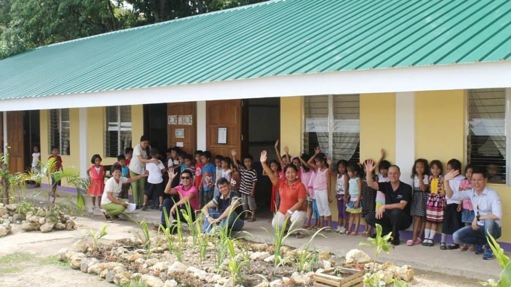 Children and teachers gathered outside a school building